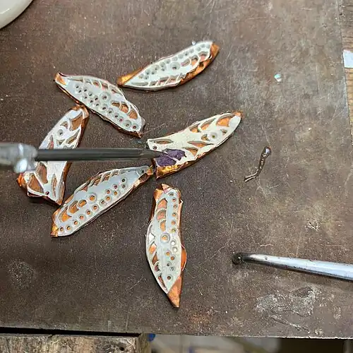 9. The enamel powder is applied wet. Capillary action helps fill the shapes and reduces the space between the grains of color. This prevents bubbles from forming as the piece is fired.