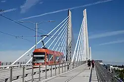 A view of the Tilikum Crossing bridge from the pedestrian and bicycle lane with a streetcar passing by