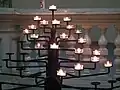 Votive candle rack that resembles a candelabra in a church in Germany
