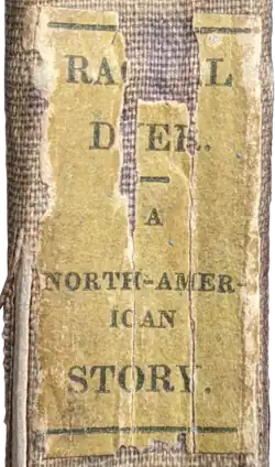 Yellowed white sticker with black letters that is cracked and missing pieces