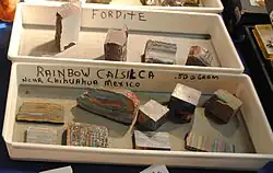 Raw and unpolished fordite on display above rainbow calsilica, which is meant to emulate fordite, 2016