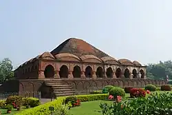 Rasmancha, Bishnupur. Built by King Bir Hambir, the temple has an unusual elongated pyramidical tower, surrounded by hut-shaped turrets, which were very typical of Bengali roof structures of the time.