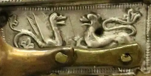 A griffin and lion face each other in hostility, indicated by their raised hindlegs. The figures are placed above Jesus' left arm.