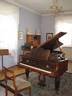 Room in old house with grand piano in the centre