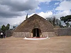 Photograph of King's palace in Nyanza, Rwanda depicting main entrance, front and conical roof