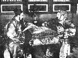 A black-and-white image of two men dressed in imperial garb playing a board game