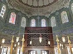 View of the tiled walls and the wooden throne above Mehmed's cenotaph