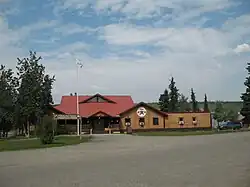 The Selkirk First Nation administrative building is shown in the summer. It’s a relatively modern building with a wooden log facade and red roofs