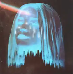 The computer graphic of a woman's head that is blue and transparent, floating in the darkness, with a beam of multi-colored light coming from her forehead