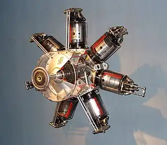 Close up image of a machine with six cylinders protruding from a center piece.