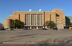 Photograph of the auditorium that is mostly rectangular except for a lower cylindrical portion on the left lower edge covering the ramps and a portion projecting above the roofline to the right