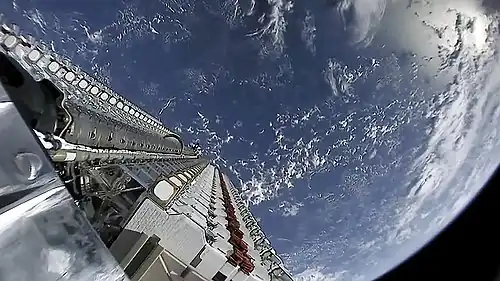 A batch of small satellites attached to the rocket with the Earth in the background