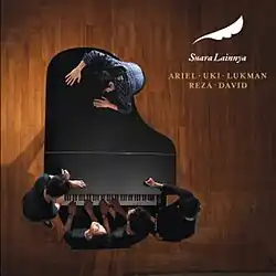 Uki, Lukman, Reza and David sitting in front of a piano while Ariel stands on the opposite side of the piano.