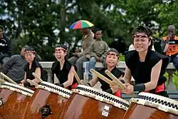 A photograph of four women in a kumi-daiko group performing in Paris, France.