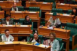 Kemp sitting at a table giving a speech
