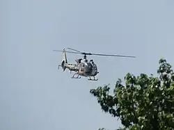 An Aérospatiale Gazelle flying above the crowd.
