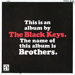 The words "This is an album by the Black Keys. The name of this album is Brothers," in block letter on a black background. "The Black Keys" is in red while the rest is in white.