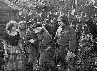 Cropped advertisement image showing a grouping of people including soldiers