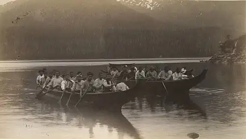 Photo of two large canoes with many rowers