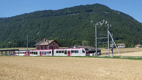 Pink train next to a field