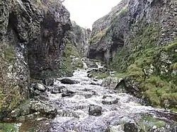 Entrance to Trollers Gill in spate