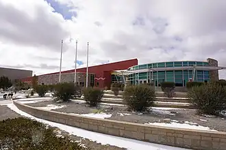 Modern one-story school building with large snow patches in the landscaping.