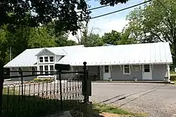 A one-story light gray wood siding building.