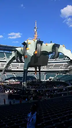It's still daytime, and the spire stands out against a clear blue sky. The stage is empty and audience members are just starting to arrive at Lincoln Financial Field in Philadelphia.