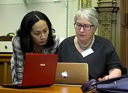 Two people working together intently on two laptops