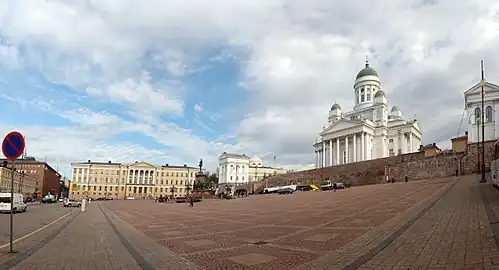 The red building on the left breaks the architectural style of the square