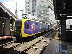 A 1200 class train with wrap advertising at Vito Cruz in August 2023.