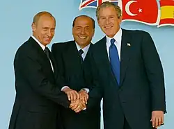 Putin with Italian prime minister Silvio Berlusconi and U.S. president George W. Bush at the NATO-Russia Council meeting in Rome on 28 May 2002[294]