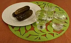 Image 28Clear vodka served with pickled cucumber – the usual way of consuming vodka in Slavic countries of the so-called "vodka belt". (from List of national drinks)