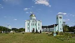 One-dome church and a building painted light blue and white on the outside