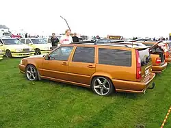 Rear drivers side view of a saffron coloured V70 R