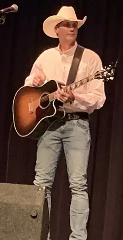 Singer Wade Hayes, holding a guitar while onstage