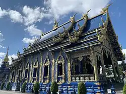 A richly ornamented Thai Buddhist temple building in striking blue and gold colours