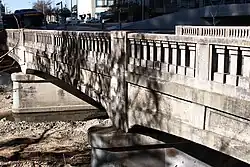 An arched concrete bridge viewed from an angle at one end