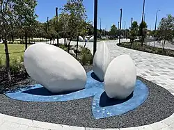 A group of three white sculptures of a large mussel