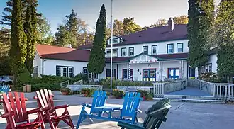 Photograph of a two-story frame building with casual decorations and a garden in front