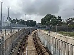 A curved railway line in a concrete structure with retaining walls