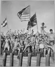 Allied prisoners of war at Aomori camp near Yokohama, Japan, waving flags of the United States, Great Britain, and the Netherlands in August 1945